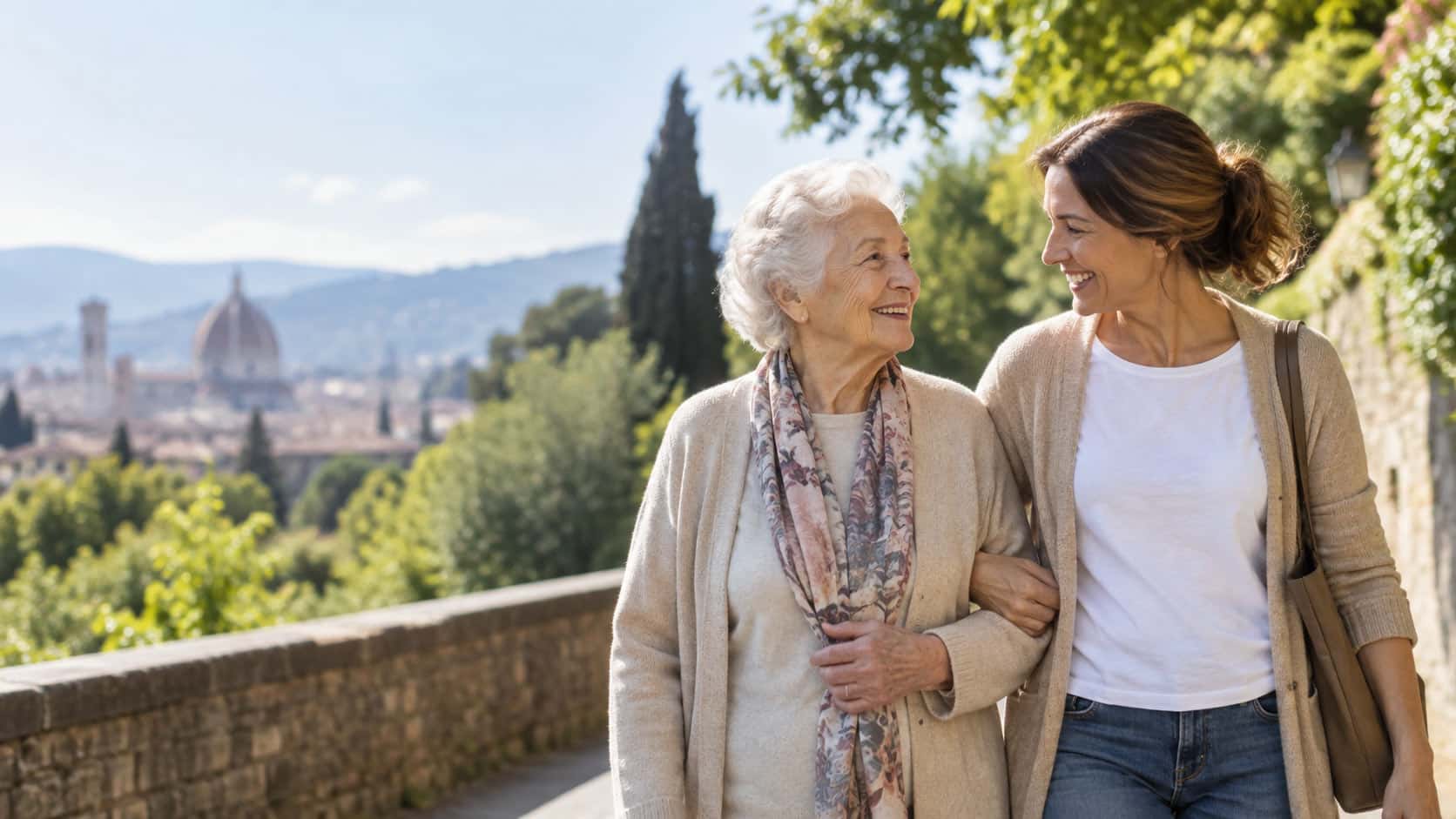 Donna anziana e caregiver passeggiano insieme a Firenze, a rappresentare il sostegno alle persone con Alzheimer e alle loro famiglie.